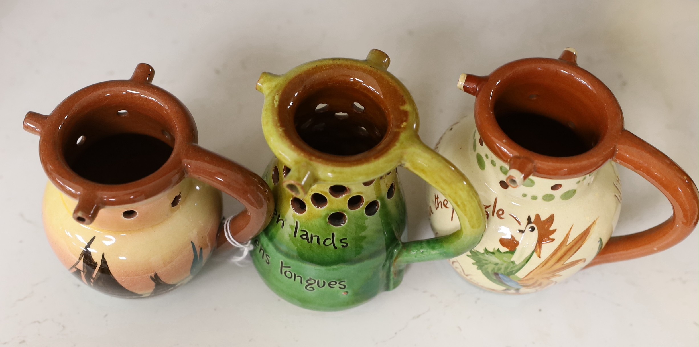 Three West Country mottoware puzzle jugs. Tallest 12cm